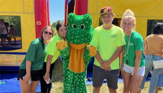 Parks employees pose with Freckles the frog