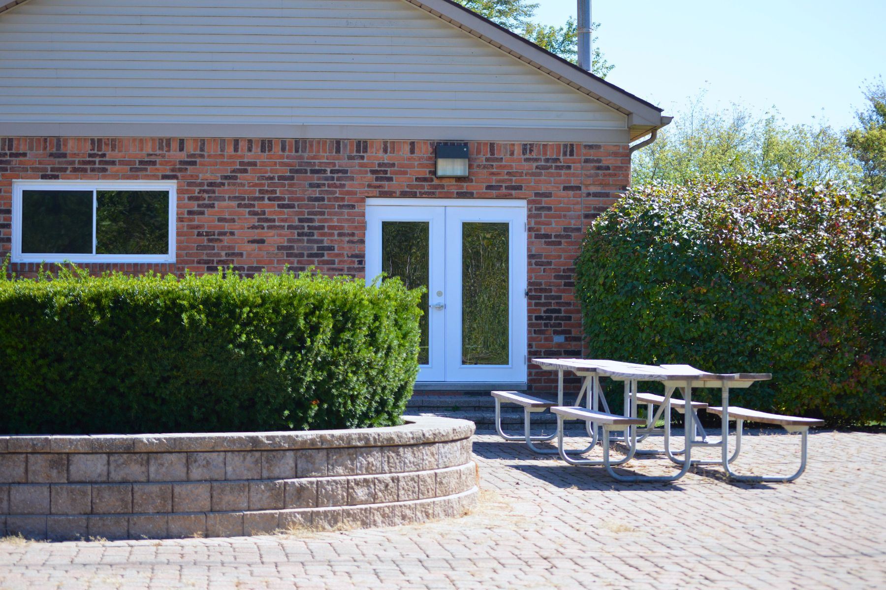 Side of the Lucido River Park building with patio and picnic table 