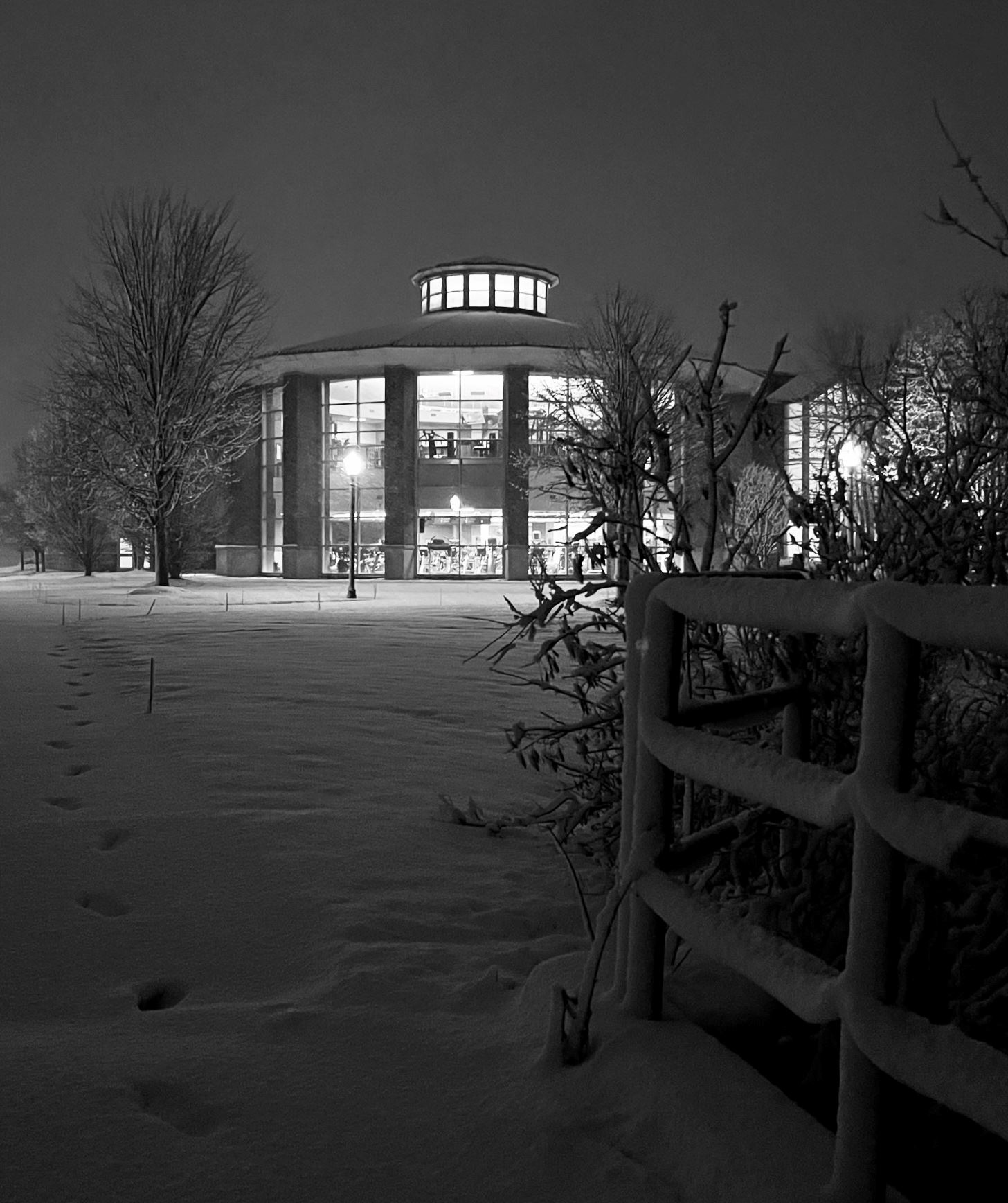 Black and white photo of the Recreation Center covered in snow, taken from the connecting pathway.